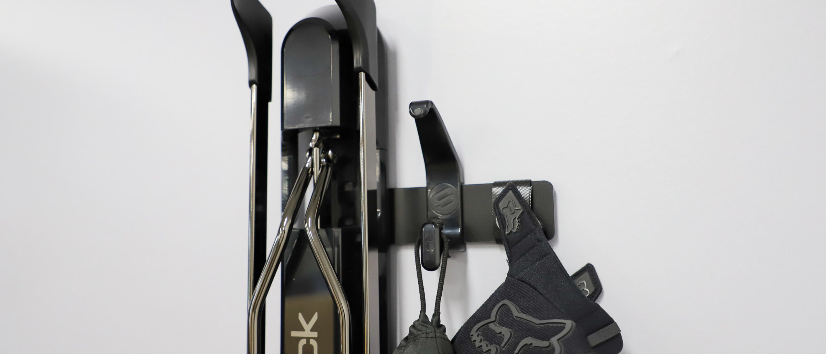 Close up of a Steadyrack bike rack with a small black metal brackets, holding a hook and velcro strap. 