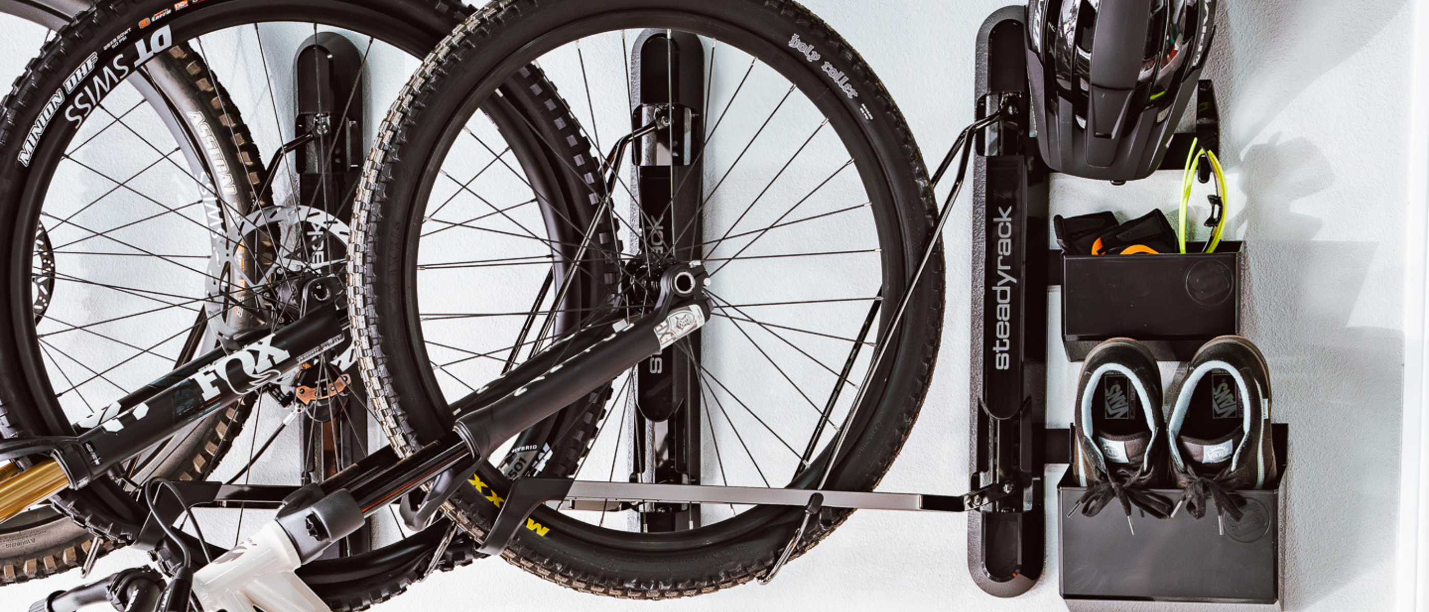 Bicycle mounted on a wall rack with tools in a holder.