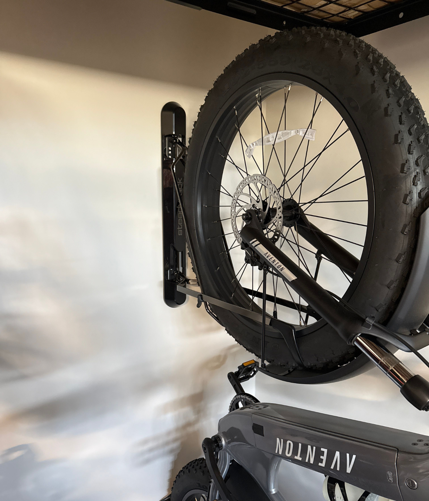 A fat tyre bike mounted in a black wall mounted bike rack