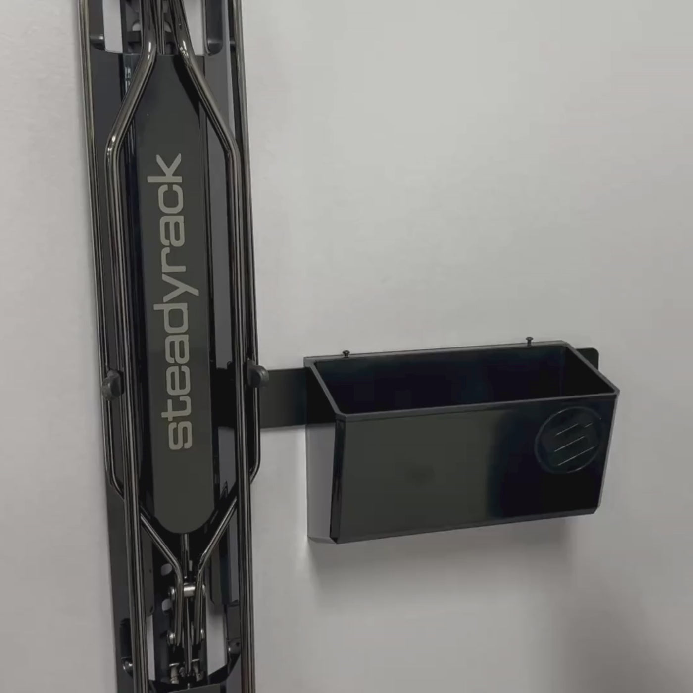 A person putting sports gels and a sunglasses holder in a black storage bin.