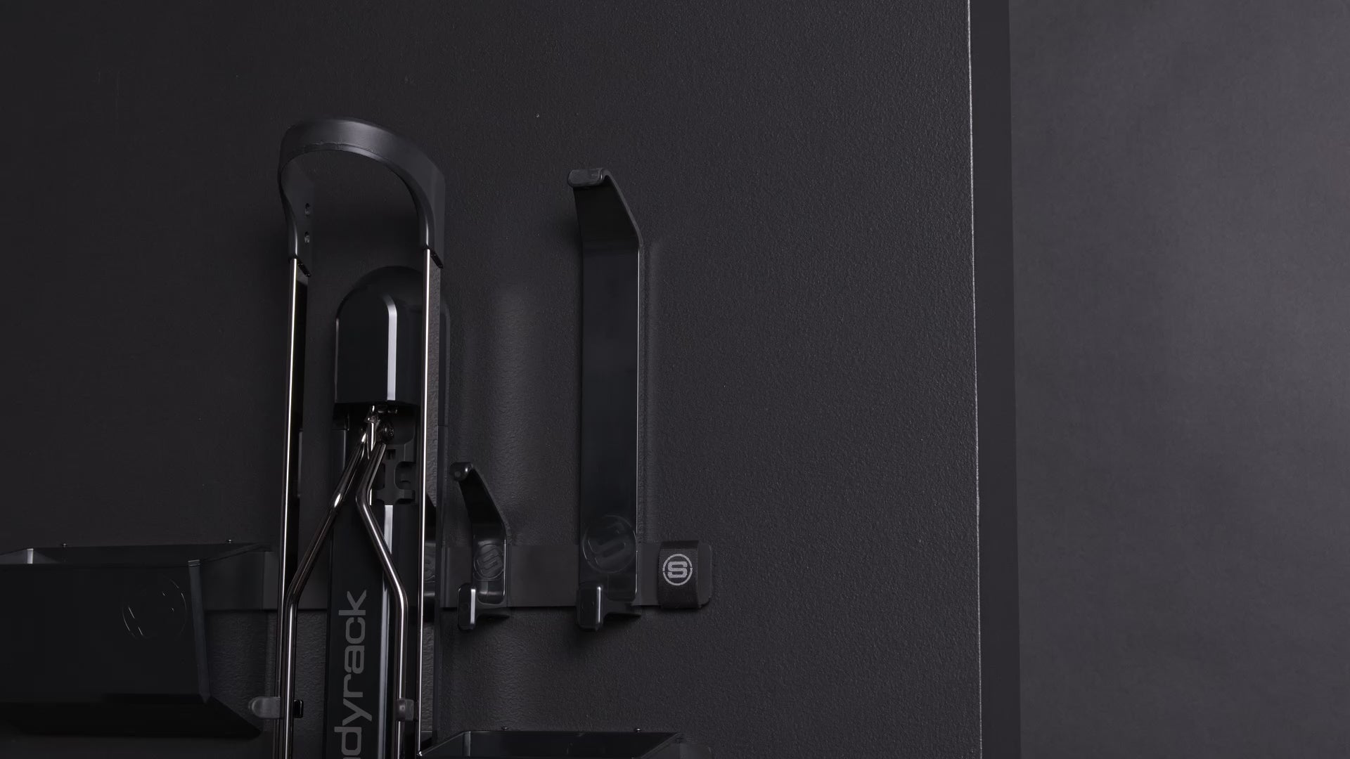 A person hanging a white helmet on a black hook. 