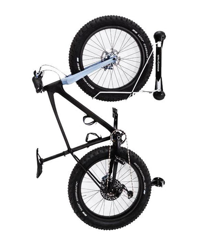 A black fat tire bike hanging vertically on a wall mounted fat tire bike rack